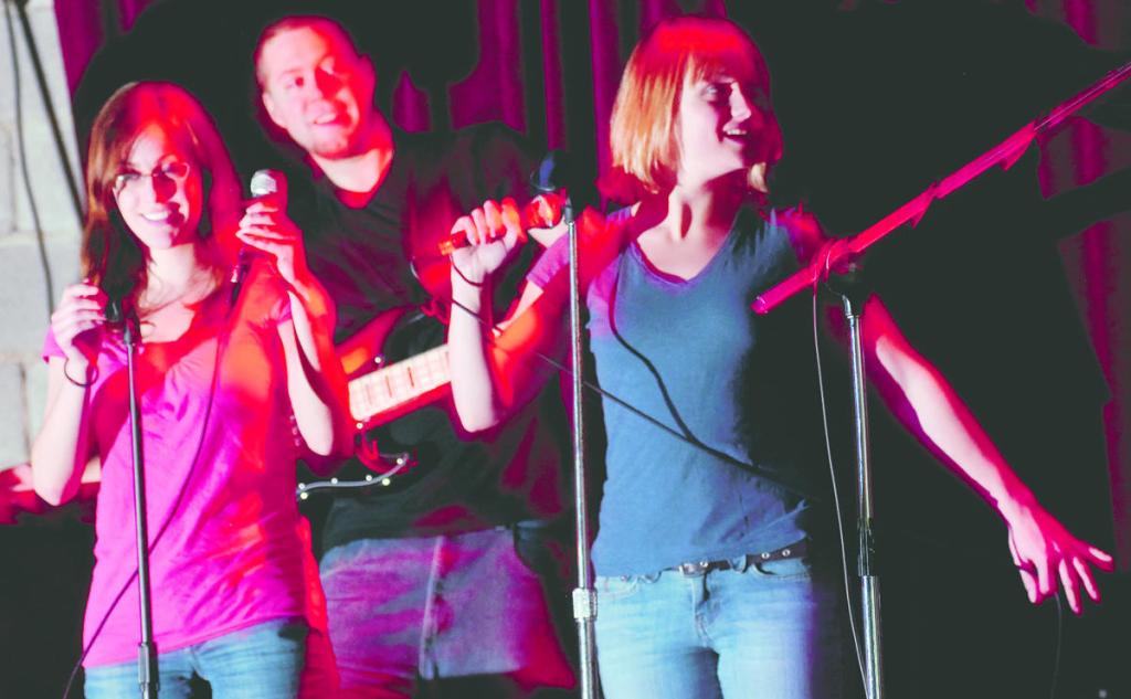 Sarah Fortin, left, of Orono and Rebecca Ewald of Portland sing with the band Trainwreck including Keith Mann, center, playing the bass, on a Wednesday at Empire Dine and Dance in Portland.
