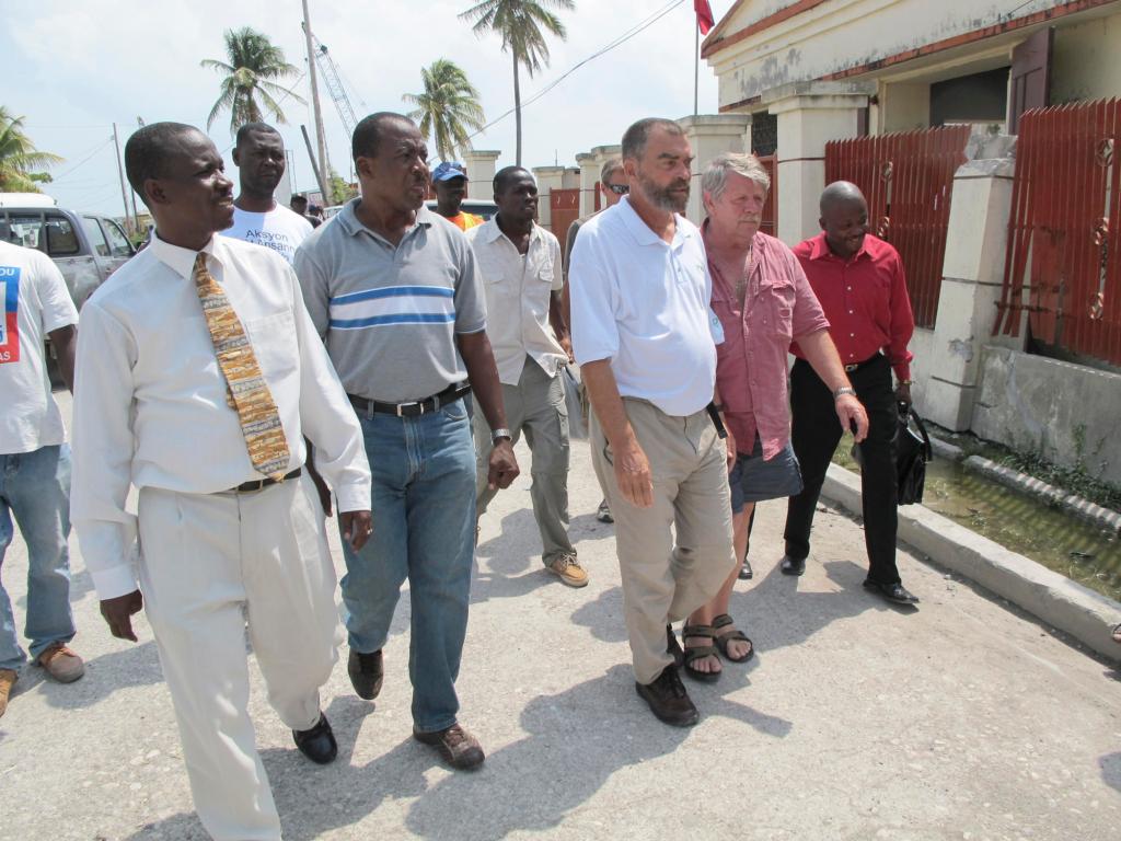 Lewiston native Father Marc Boisvert, third from left, is flanked by Sea Hunter owner Greg Brooks of Gorham as they walk from one meeting with government officials to another Wednesday in Les Cayes, Haiti.
