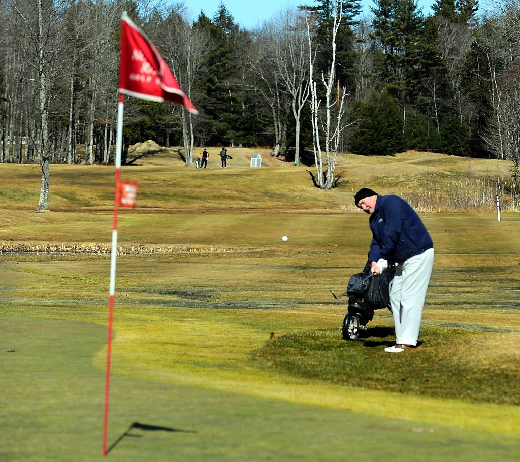 Peter Allen of Portland chips to the green on the third hole of Nonesuch Golf Course in Scarborough on Friday. Warm weather has encouraged many golfers to start the season early, and tee times are sold out today at Nonesuch, says Dan Hourihan, owner and manager. It’s just one of the signs that this hasn’t been a typical Maine winter.