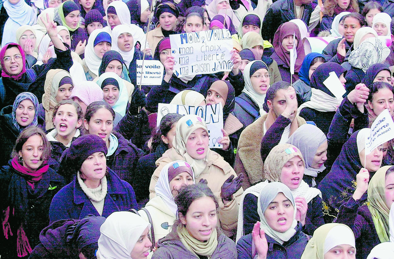 People demonstrate in Paris in 2003 to protest a law banning Islamic head scarves and other religious insignia in public schools. Hani Khan, a 19-year-old California woman, says she was fired last month from a Hollister Co. clothing store for wearing a head scarf, or hijab, to work.
