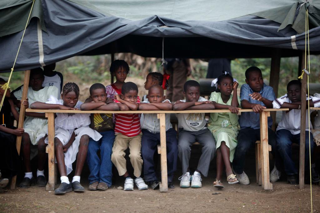 Children wait for the inauguration of a school that will be run by an Israeli group at a camp for earthquake survivors inPort-au-Prince on Friday. Donations from around the world have poured into Haiti since the January disaster.
