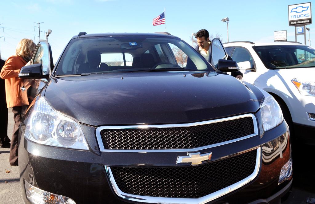 Joanne and Dan Ganim of Hamilton, Mass., look over a Chevrolet Traverse at a Danvers dealership. GM has about 5,500 dealers nationwide.
