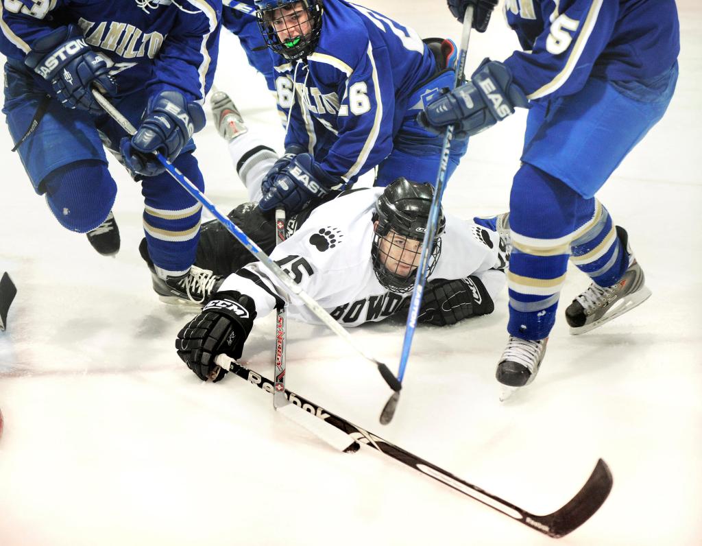 Bowdoin’s Robert Toczylowski lunges for the puck after being pulled down by Hamilton defenders Saturday during their NESCAC men’s hockey semifinal in Brunswick. Bowdoin advanced to face Middlebury for the league title.