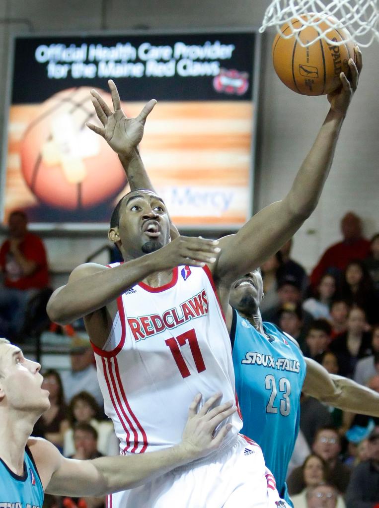Darnell Lazare of the Red Claws slides between Greg Stiemsma, left, and Raymond Sykes of Sioux Falls for a layup Sunday night during the Skyforce’s 99-98 victory at the Portland Expo.