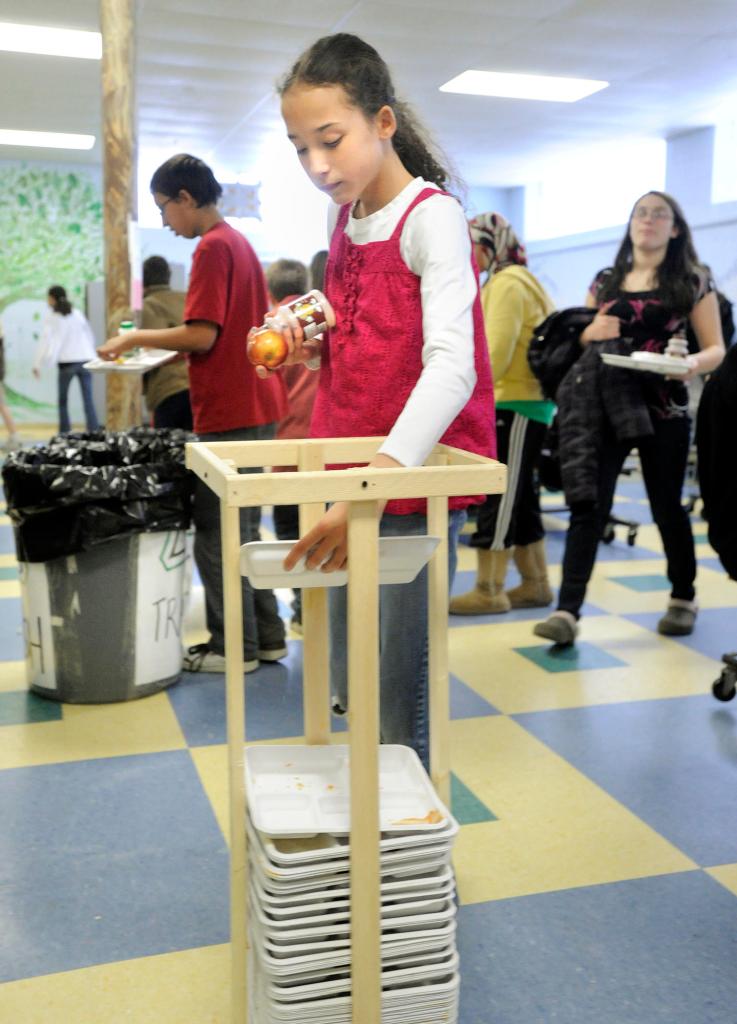A student recycles a paper lunch tray Monday as Lincoln Middle School in Portland kicked off its cafeteria recycling pilot program.