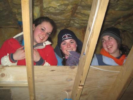 Students Katie Savidge, Kate Dodge and Mary Foster install insulation in a Habitat for Humanity home in Freeport.