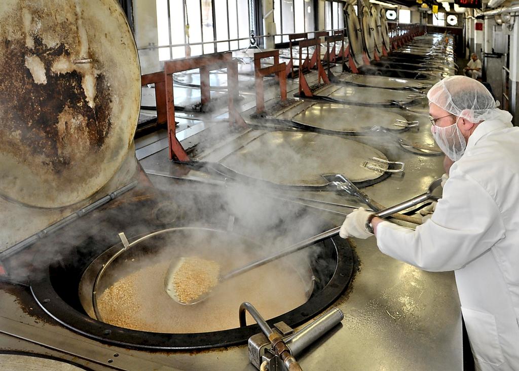 Ray Routhier stirs one of the many pots of beans baking in a 450-degree oven at B&M Baked Beans. It takes a shovel-sized implement to handle the contents of this pot.