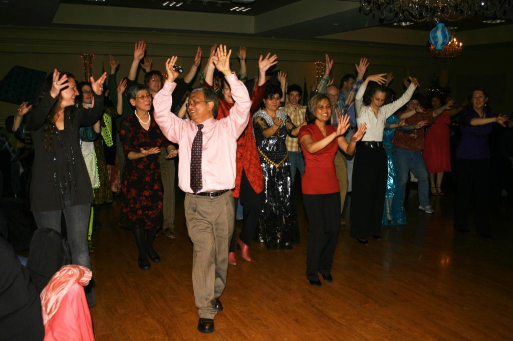 Peng Kem and his wife, Veasna Kem, lead the crowd in a Cambodian dance.