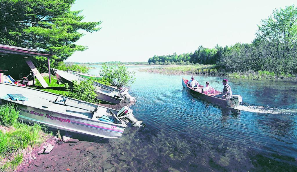 Fishermen and their guide head out onto Big Lake in Princeton for a day of smallmouth bass fishing from a camp on the shore of Grand Lake Stream.