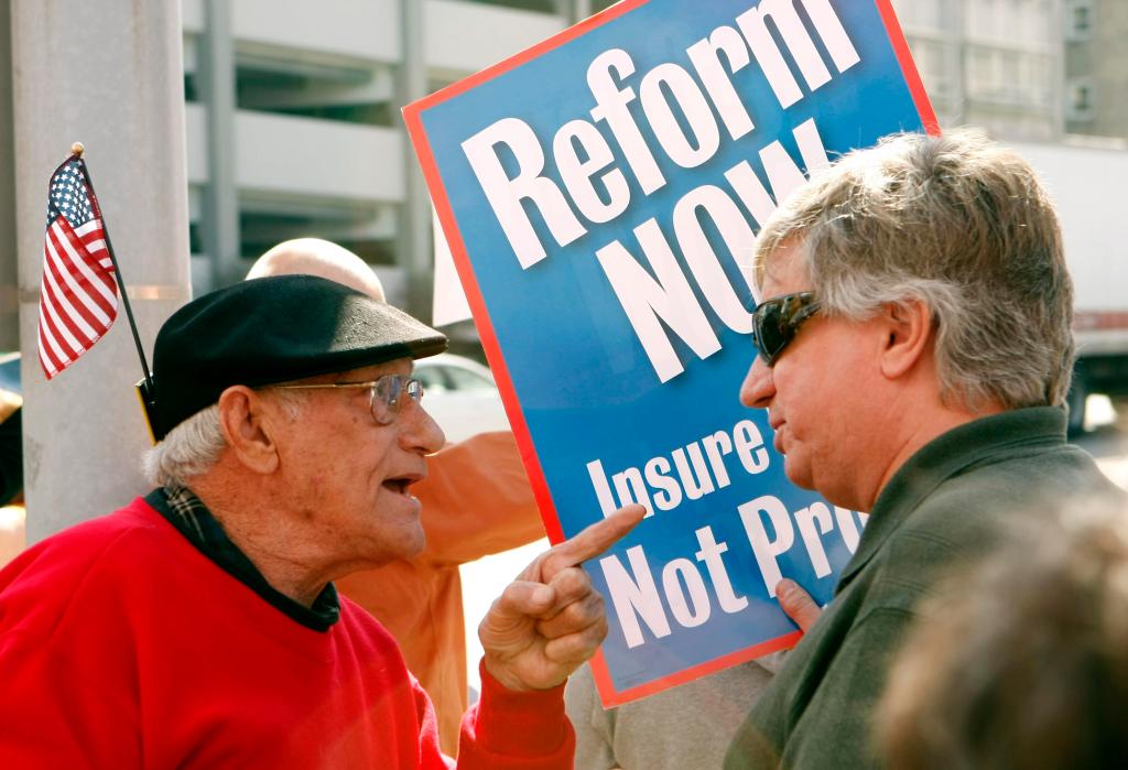 George Martin, left, and Walt Stoelting argue over health care reform during a rally Thursday outside the district office of Rep. Joe Donnelly in South Bend, Ind. Groups on both sides of the debate are keeping pressure on three Indiana Democratic congressmen, including Donnelly, who say they haven’t decided how they’ll vote.