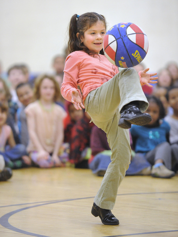 Reiche first-grader Ingrid Rosales demonstrates another trick Branch taught students in last Friday’s visit, bouncing the ball off her knee to a teammate.