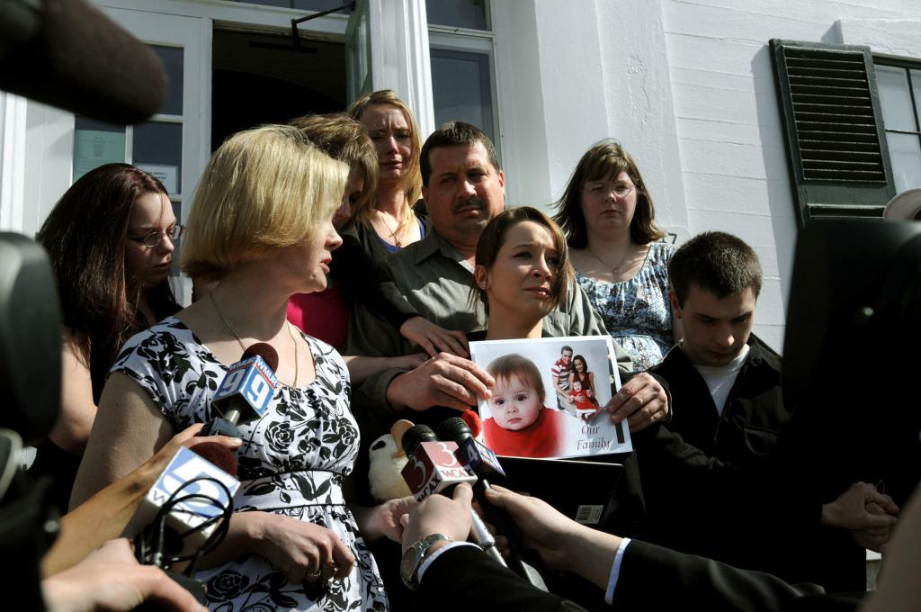 Janine McDaniel, left, of Andover, N.H., speaks outside of court Friday about the death of her granddaughter, one-year-old Kyleigh McDaniel. Kyleigh’s mother, MacKenzie McDaniel, also of Andover, N.H., holds photographs of her daughter.