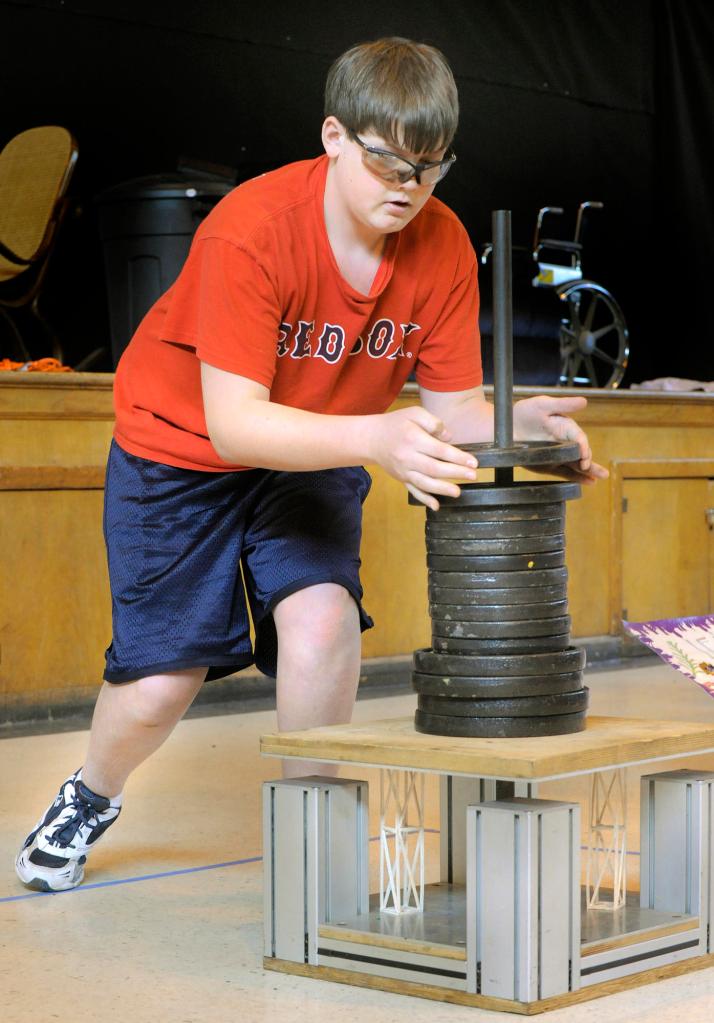 Brady Grotton from Jefferson Village School lowers weights down onto two balsa wood columns as his teammates perform a skit in the Column Structure challenge.