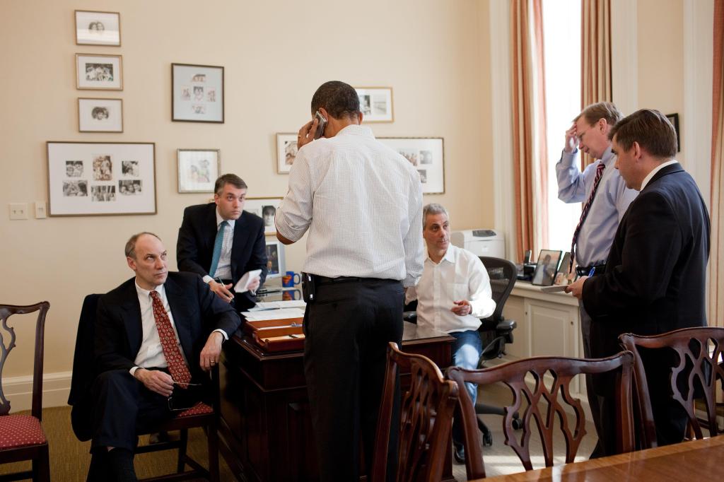 This photo provided by the White House shows President Obama talking on the phone with a member of Congress in the office of his chief of staff, Rahm Emanuel, at the White House on Sunday. Aides are, from left, Phil Schiliro, Sean Sweeney, Emanuel, Jim Messina and Dan Turton.