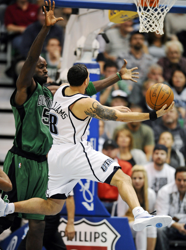 Utah guard Deron Williams drives to the basket against Kevin Garnett of the Celtics during Monday’s game at Salt Lake City. Williams finished with 22 points and 11 assists, guiding the Jazz to a 110-97 victory.