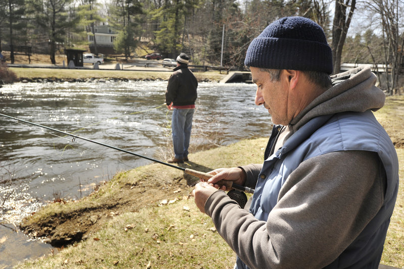 Stephen Sparaco, a Maine Guide from Standish, ties on a new fly before casting Friday at the Songo Locks in Naples. The area is typically lined with fishermen for the first days of the open-water season.