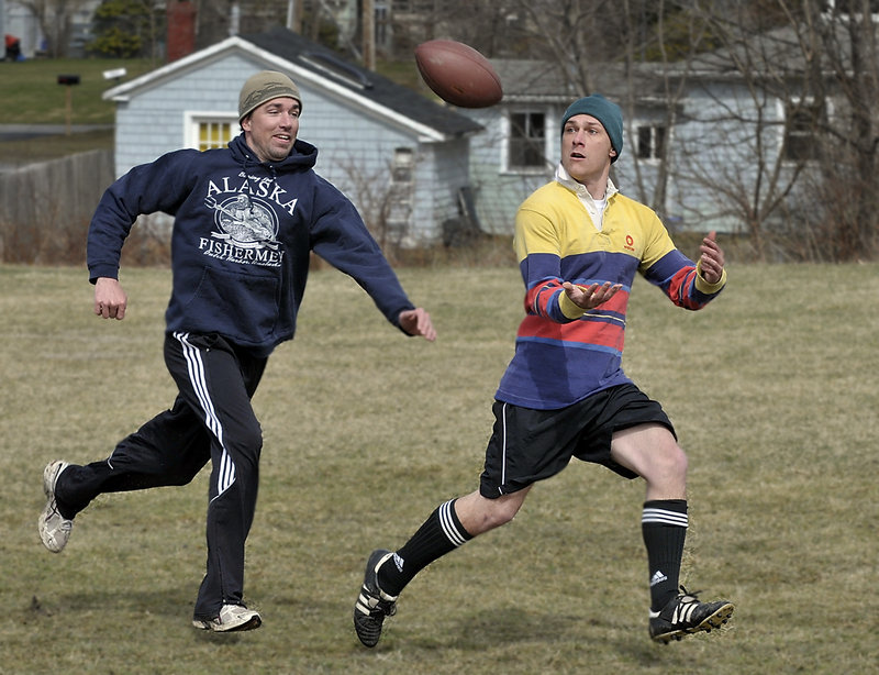 Mike McCoy, right, prepares to make a reception for a touchdown with Shannon Carroll in pursuit as they and other law students from the University of Southern Maine play their weekly football game in Payson Park in Portland. Carroll said he and seven friends have been playing at the park every Friday since February, rain or shine.