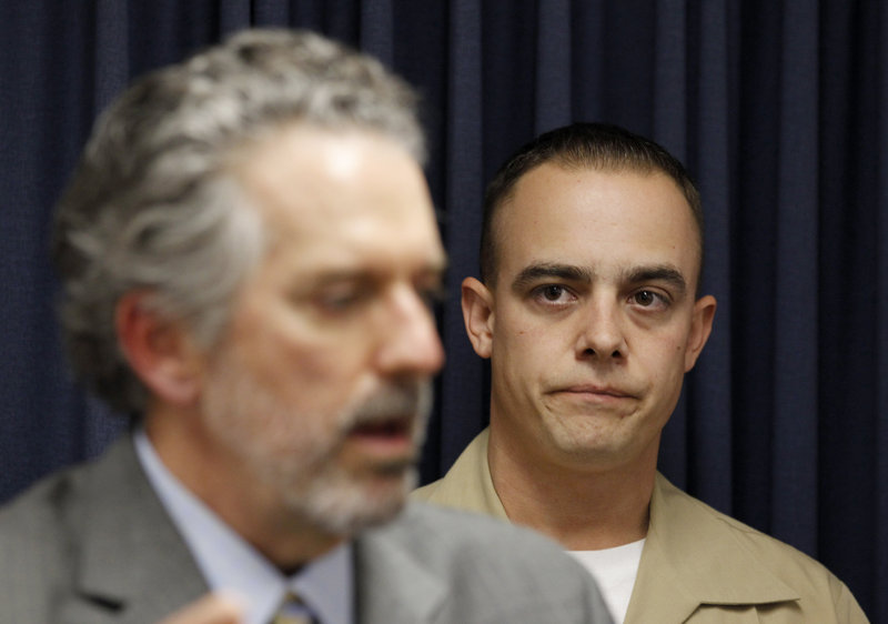 Marine Corps Staff Sgt. Frank Wuterich, right, listens as his attorney, Neal Puckett, talks to the media Friday.