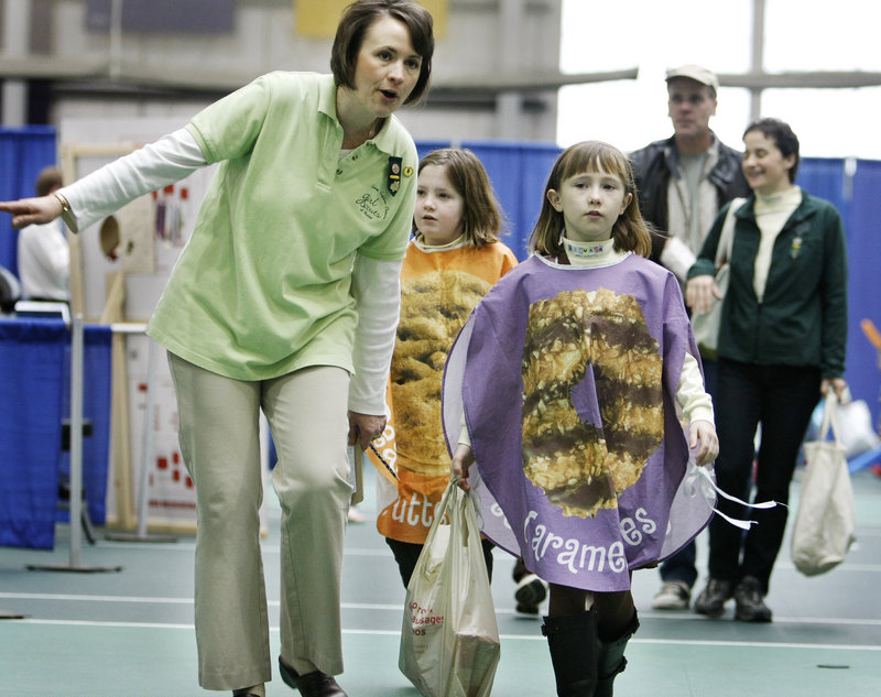 Kristin Larkin, a leader with Brownie Troop 1173 in Gorham, walks her daughter Kate Larkin, 8, and Brenna Donovan, 9, around to deliver Girl Scout Cookies to vendors at the Gorham Marketplace on Saturday at USM in Gorham.