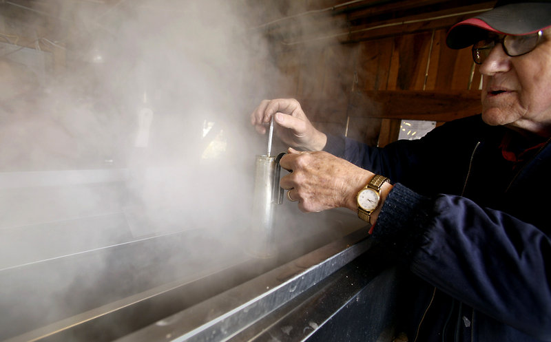 Clark Cole uses a hydrometer to measure the density of the syrup in the evaporator in his family's sugarhouse.