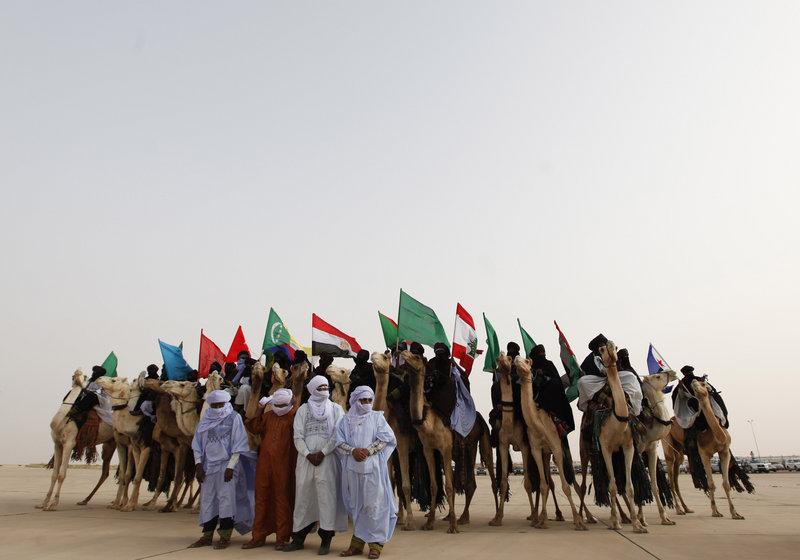 Libyan camel riders holding flags of Arab countries gather as Arab League leaders arrive for the summit in Sirte, Libya.