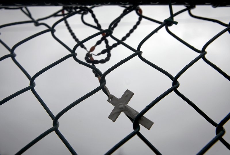 A cross hangs on a fence near the train station in Patchogue, N.Y., where Ecuadorean immigrant Marcelo Lucero was killed in a hate crime in 2008.