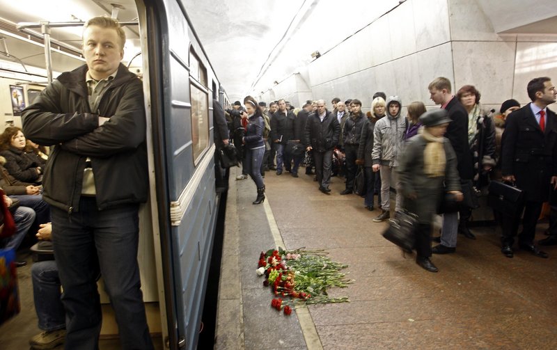 Commuters walk past flowers on the platform at the Lubyanka subway station in Moscow, which was hit by one of two explosions during rush hour on Monday.