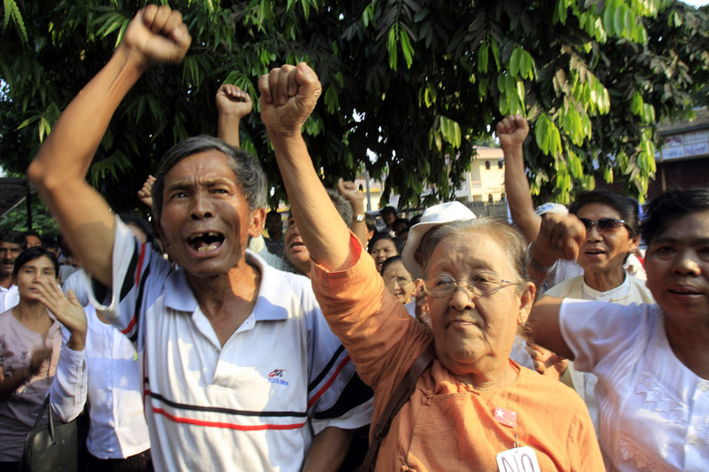 Members of detained pro-democracy leader Aung San Suu Kyi’s National League for Democracy Party chant slogans demanding her release in a rally outside the party’s headquarters Monday in Yangon, Myanmar.