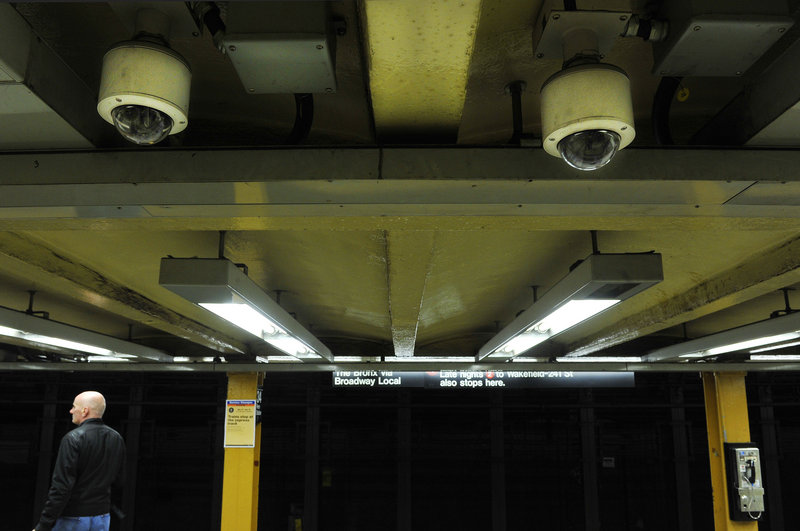 Two ceiling-mounted video cameras keep watch over the 34th Street station in New York. About half of the 4,313 cameras installed along the city’s public transit system aren’t operable, and cuts in the number of transit police patrols, possibly weakening city security.
