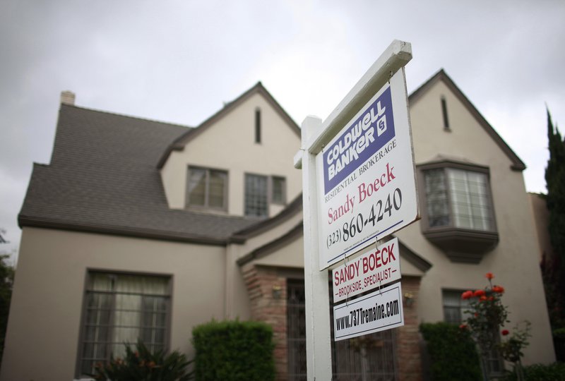 A “for sale” sign is posted Tuesday in front of a home in Los Angeles. A price increase of 1.8 percent in the city’s real estate market in January helped lift a key home index for the eighth month in a row.