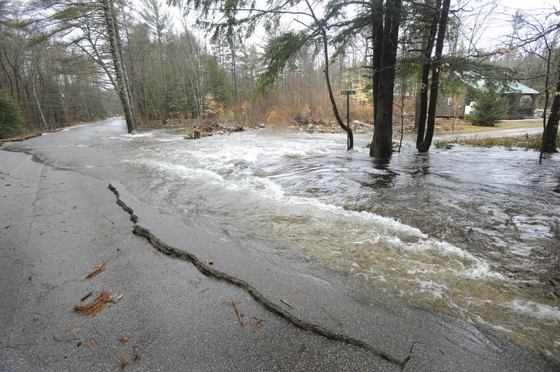 A dam break Tuesday morning causes flooding on Porter’s Colcord Pond Road as well as part of the nearby Dam Road.