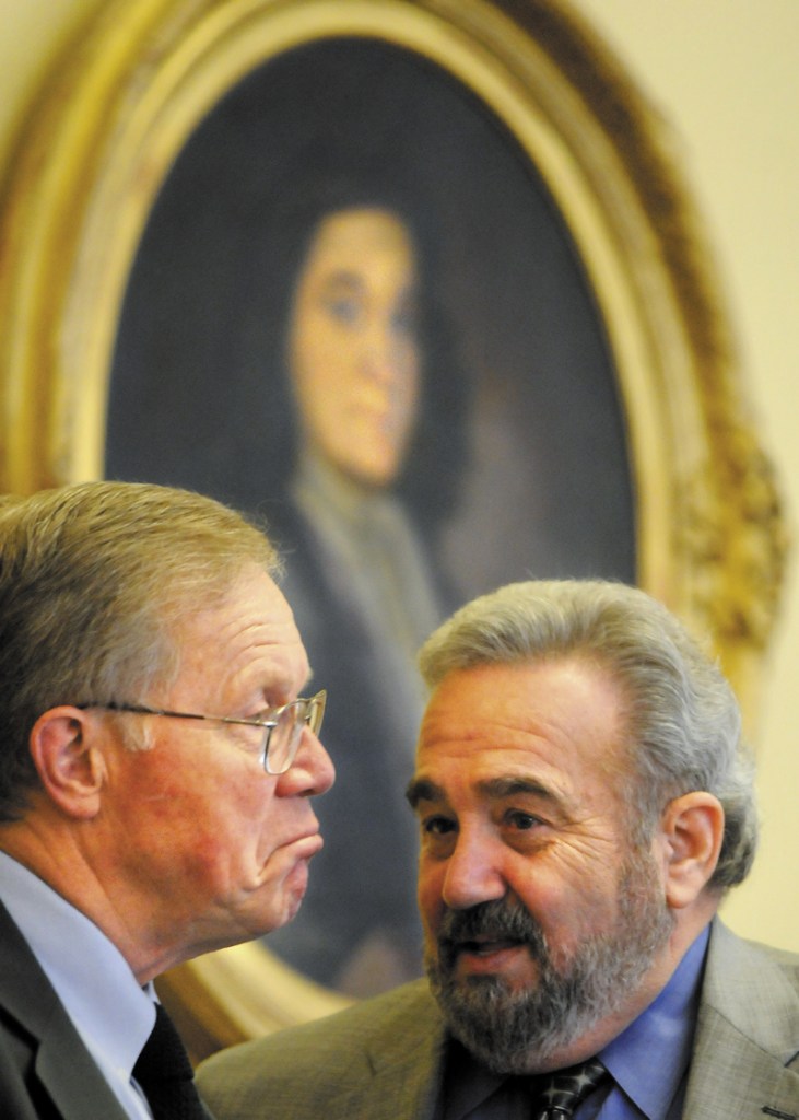 Maine Sens. Richard Nass, R-Acton, and Stanley Gerzofsky, D-Brunswick, confer beneath a portrait of William Phips in the Maine Senate on Tuesday. The Legislature completed work on a supplemental budget that closes a $310 million shortfall and took hundreds of hours to craft.