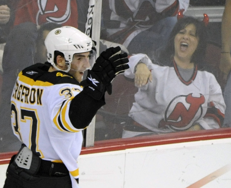 Patrice Bergeron of the Boston Bruins celebrates his overtime goal Tuesday night against the New Jersey Devils. Bergeron was pleased. The Devils’ fan? Not so much.
