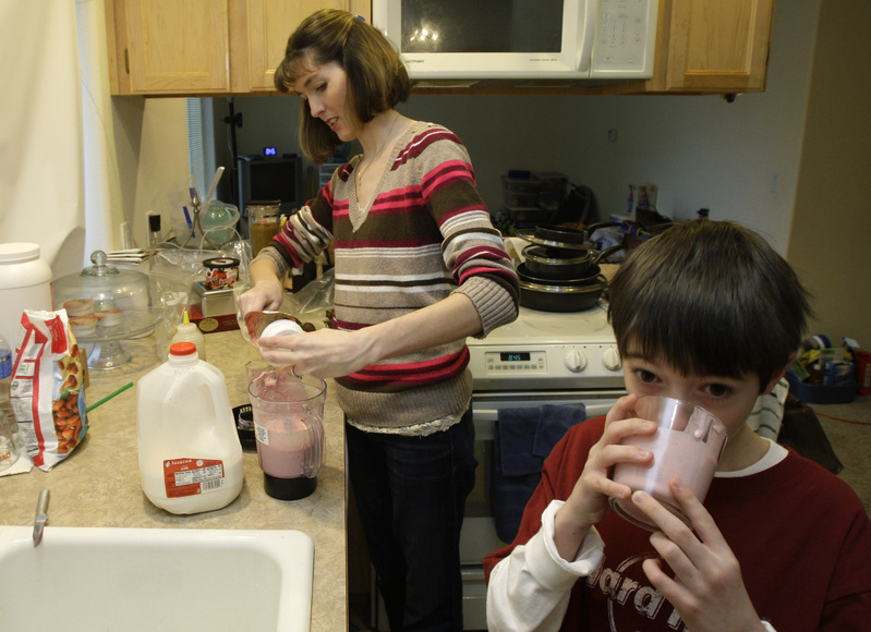 Nicole Rosen serves her son Austin Meyers, 8, a homemade smoothie at their home in Roy, Wash. Despite the difficult economy, Rosen says she and her husband have tried build up their savings and avoid credit card and other interest charges.