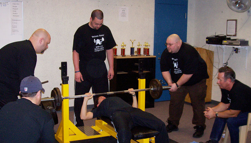 From left, Chris Bisson, seated, as a judge; spotters Erik Moody, Chris Chudzik and Don Young; Del Sargent, seated, as a judge. The lifter is Rebecca Miller.