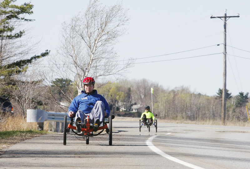 Ethan Davis, owner of Wildfire Human Powered Vehicles, foreground, and reporter Deirdre Fleming ride recumbent tricycles alongside Scarborough Marsh recently.