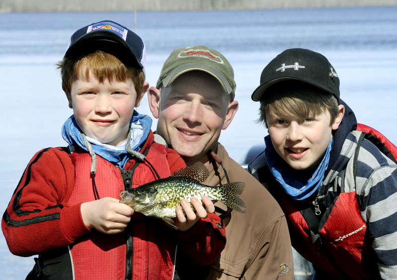 Kevin McKay, center, has taught his sons, Jax, 7, left, and Tait, 10, to fly fish. Jax holds a black crappie caught at Hermon Pond.