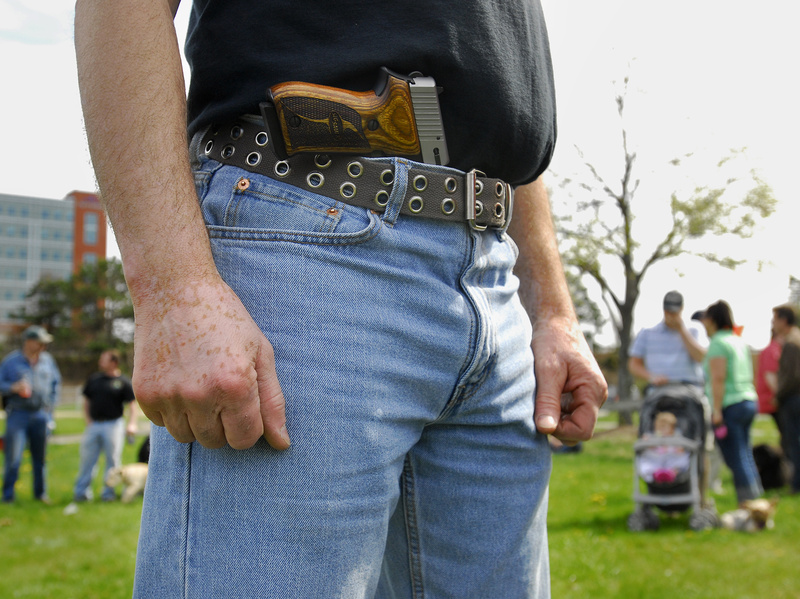 A pro-gun demonstrator who did not want to be identified stands in a park at Back Cove in Portland during an open-carry gathering Sunday to publicize the right to carry unconcealed weapons.