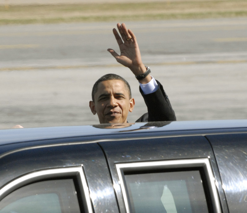 President Obama waves to the media before getting into his limo after landing at the Portland Jetport.