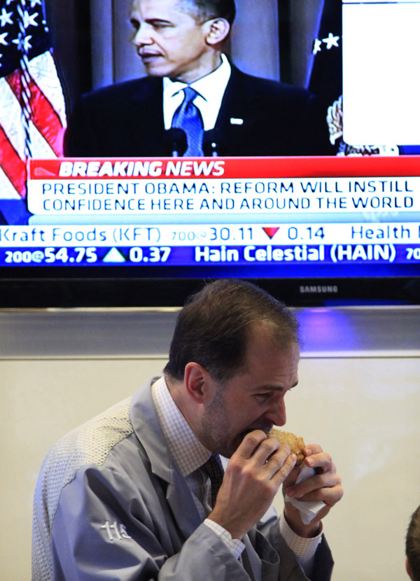 A trader eats lunch at the New York Stock Exchange during President Obama's speech today.