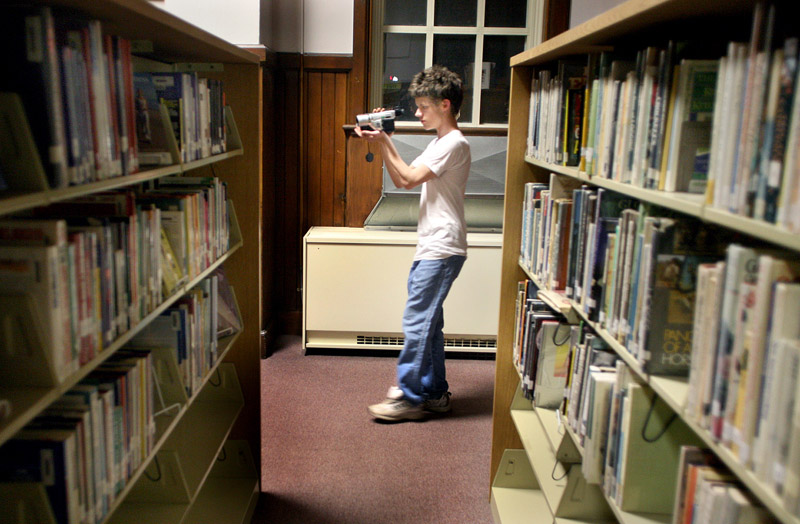 PATHS new media student Dylan Sargent, 18, films Kara Marston as she asks questions hoping to hear a response from paranormal activity in the library at Portland High School on Wednesday.