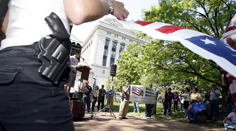 Participants openly carry handguns among a group of supporters that converged Monday for a Second Amendment Rally in Richmond, Va.
