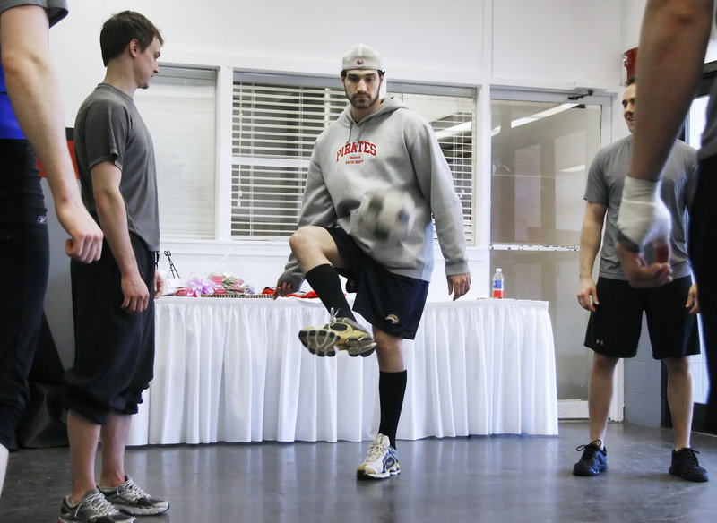 Mark Mancari of the Portland Pirates is watched by teammate J.P. Lamoureux while doing a pregame ritual of two-touch soccer at the Civic Center. The same group of players takes part before each game.