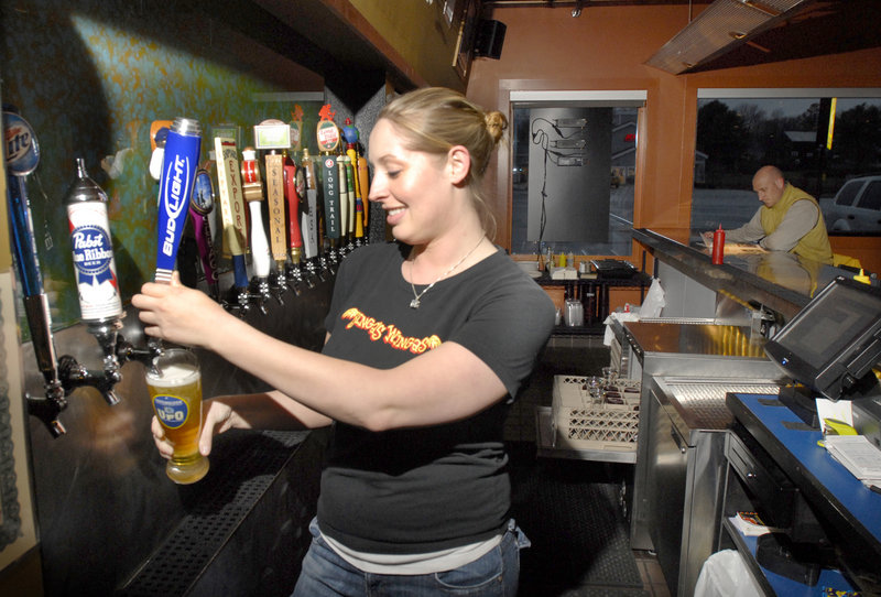 Bartender Sarah Hewes pours at Binga's Wingas in Yarmouth, where there's always a beer special and you can choose from more than 20 flavors of sauce for chicken wings and tenders.