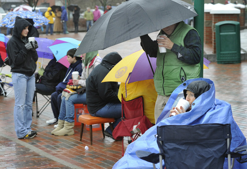 Hot coffee helps Saco resident Madelyn Belliveau, right, stay warm as she waits in line Wednesday for tickets to see President Obama. Belliveau said she arrived at 5:45 a.m. Ticket distribution began at 11 a.m.