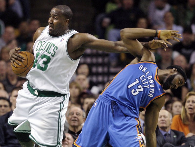 Kendrick Perkins of the Boston Celtics holds the ball with one hand and holds off James Harden with the other for a rebound Wednesday night. Oklahoma City won, 109-104.