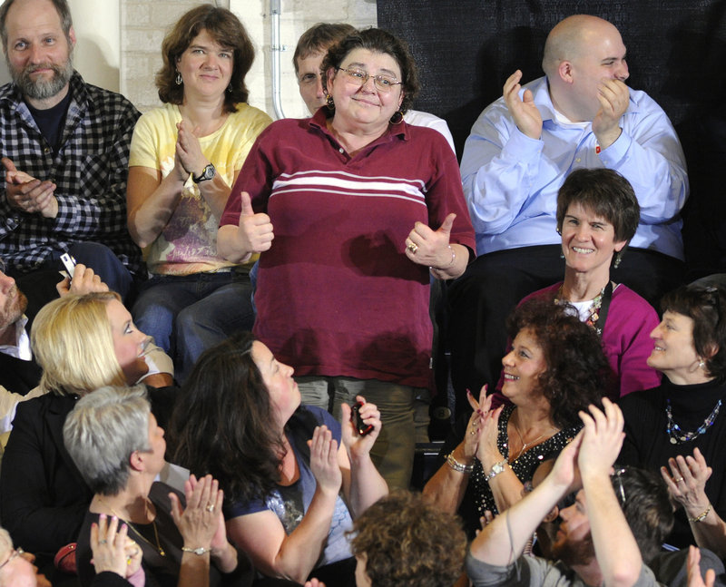 Theresa D'Andrea of Limerick gives a thumbs-up Thursday after being asked to stand up by President Obama during his talk on the health care reform law.