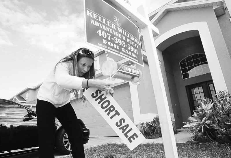 Mysty Stange puts up a short sale sign on a house in Orlando, Fla. Short sales made up 8 percent of the market in January, compared to 5 percent a year earlier.