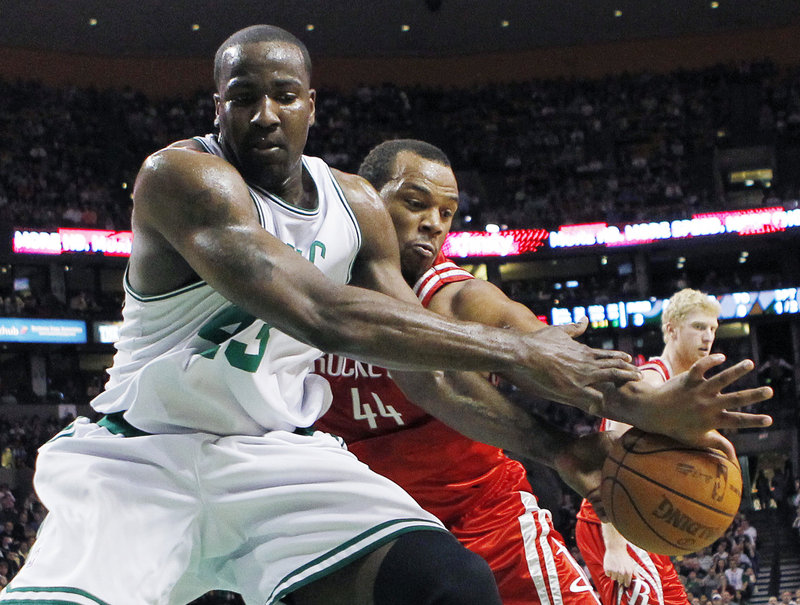 Kendrick Perkins of the Boston Celtics, left, competes with Chuck Hayes of the Houston Rockets for a loose ball Friday night in the first quarter of Houston’s 119-114 overtime victory. Boston has lost three straight home games.