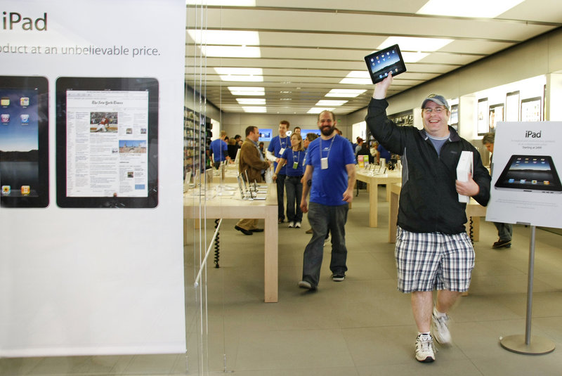 Dallas Cardinale of Maryland, who was visiting his mother who lives in Bridgton, holds up his new iPad, the first one sold Saturday at the Apple Store at the Maine Mall in South Portland.